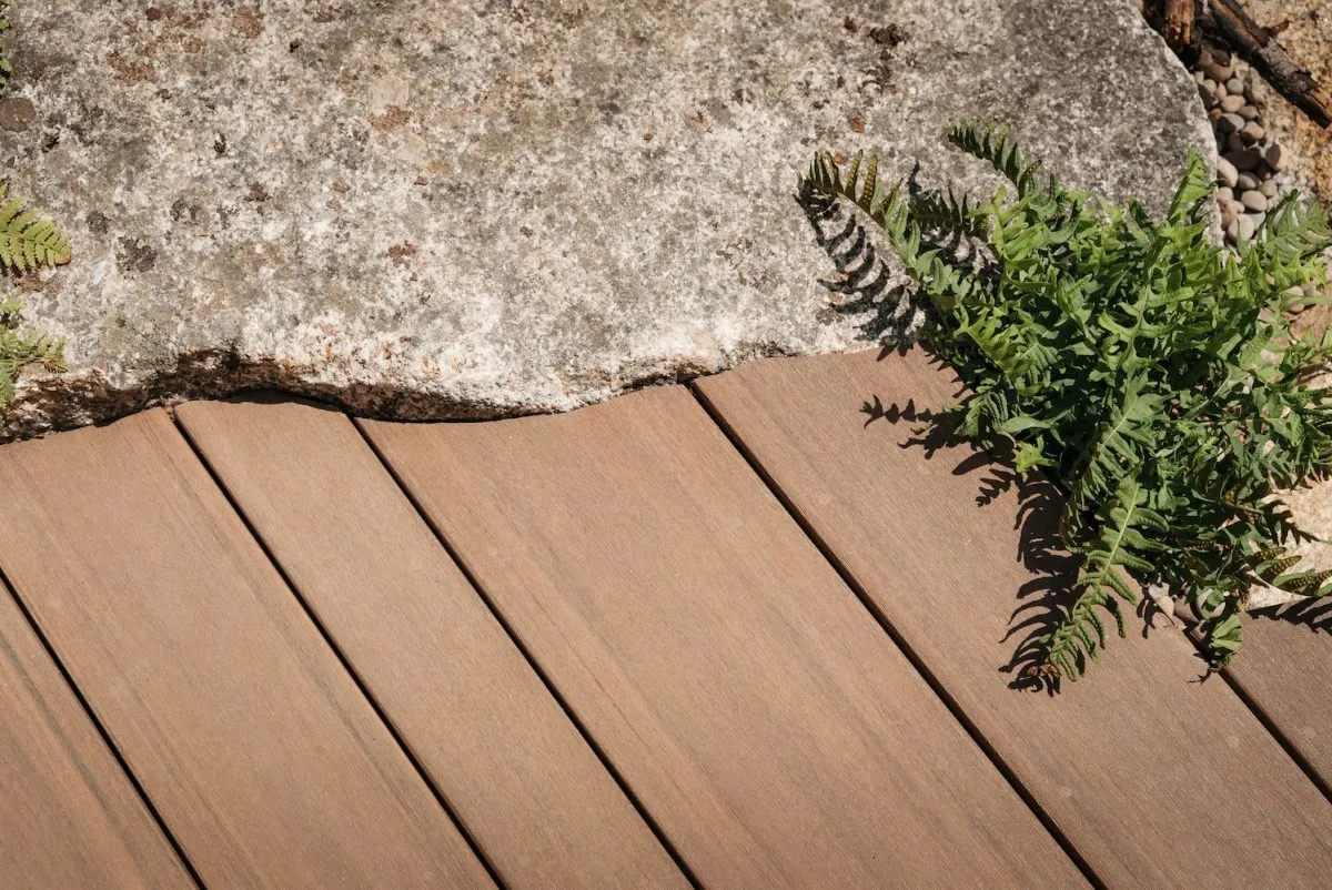 A close up of the multi width Elements decking install close up against some stones in the RHS Hampton Court garden