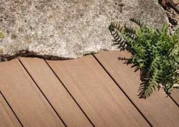 A close up of the multi width Elements decking install close up against some stones in the RHS Hampton Court garden